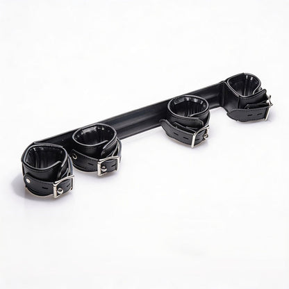 Angled view of the Deluxe Rigid Spreader Bar highlighting the four padded faux leather cuffs, rigid support bar, adjustable straps, and metal buckles