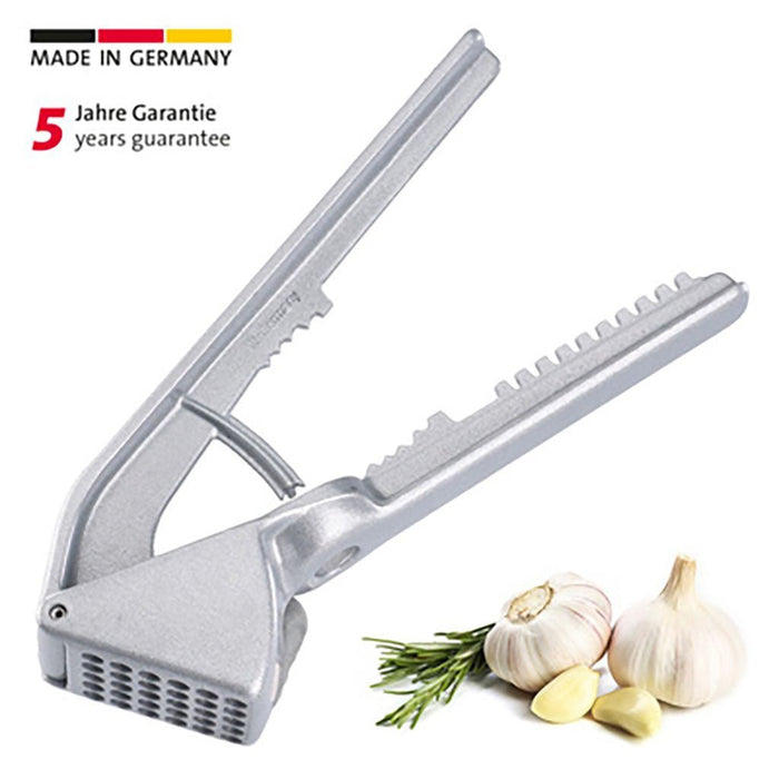 Silver garlic press with garlic and rosemary on a white background, featuring 'Made in Germany' and a warranty text.
