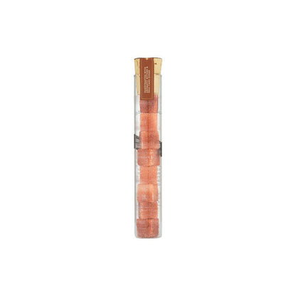 Glass vial of old fashioned sugar cubes on white background