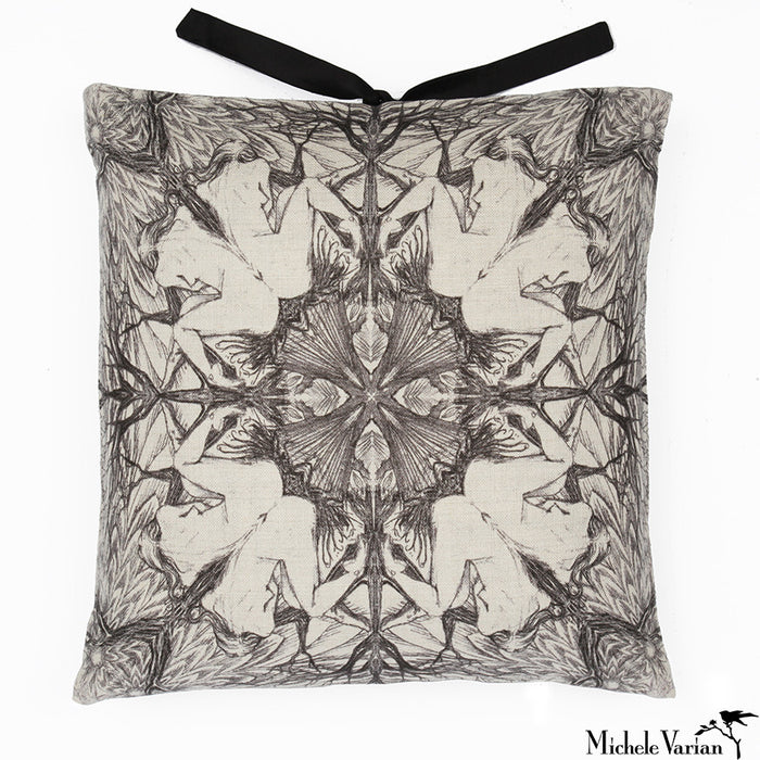 A square-shaped accent pillow with a  repeating geometric pattern of a seated woman in black and white, featuring a decorative silk tie closure at the top. Designed by Michele Varian and made in New York.