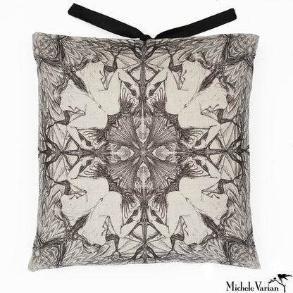 A square-shaped accent pillow with a  repeating geometric pattern of a seated woman in black and white, featuring a decorative silk tie closure at the top. Designed by Michele Varian and made in New York.