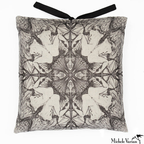A square-shaped accent pillow with a  repeating geometric pattern of a seated woman in black and white, featuring a decorative silk tie closure at the top. Designed by Michele Varian and made in New York.