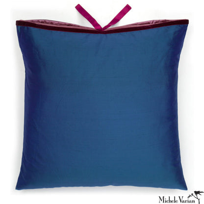 A deep blue silk square throw pillow with a lavender insert flap and a fuchsia silk tie closure on a white background. Designed by Michele Varian and made in New York.