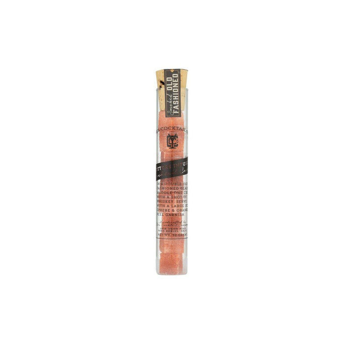 Glass vial of smoked old fashioned sugar cubes on white background