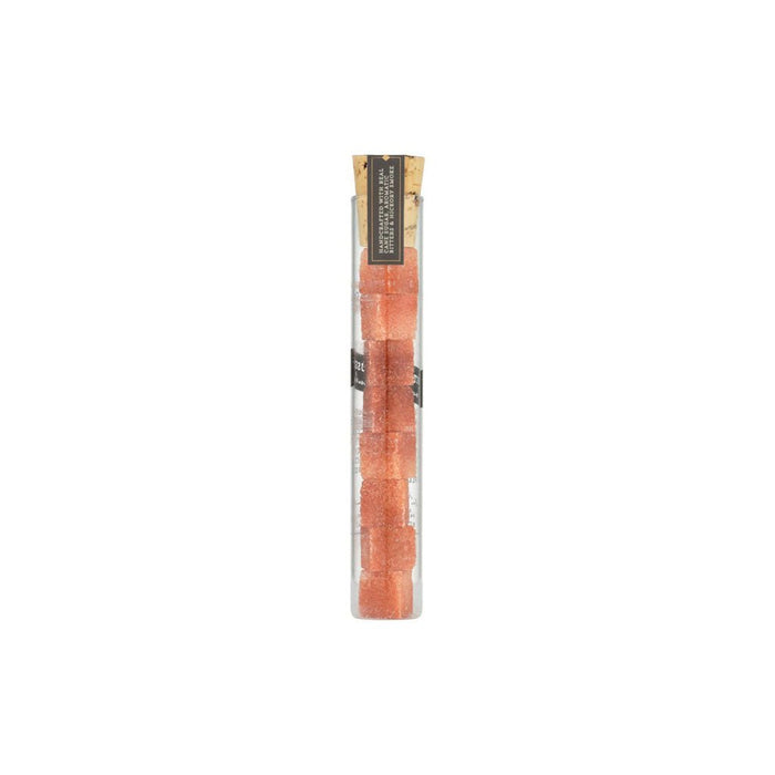 Glass tube of cocktail smoked old fashioned sugar cubes on white background